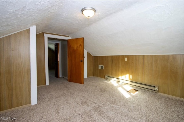 bonus room with wood walls, a baseboard radiator, a textured ceiling, light colored carpet, and vaulted ceiling