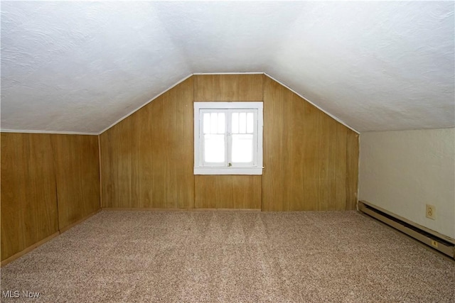 additional living space with lofted ceiling, carpet floors, a textured ceiling, and a baseboard radiator