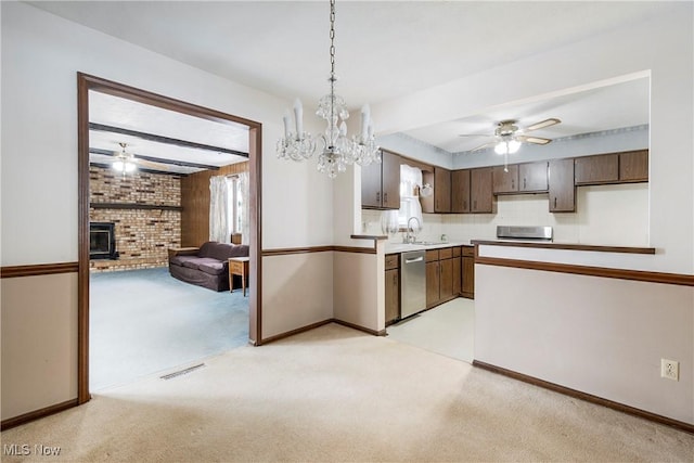 kitchen with a wood stove, light colored carpet, dark brown cabinetry, and dishwasher