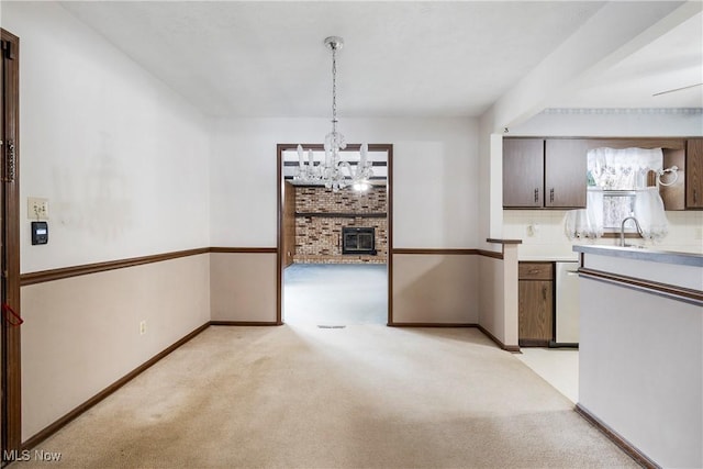 kitchen with light carpet, tasteful backsplash, a wood stove, hanging light fixtures, and sink