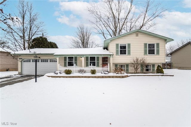 split level home with covered porch and a garage