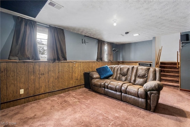 cinema featuring carpet floors, wooden walls, and a textured ceiling