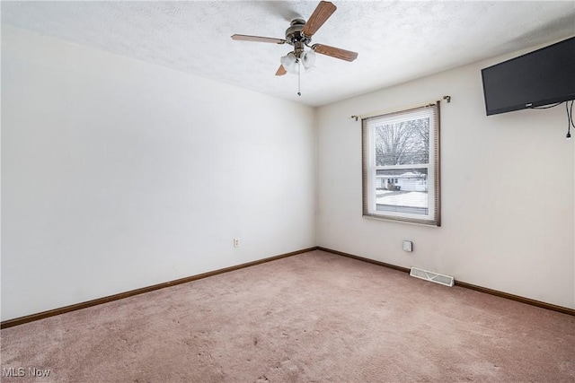 empty room featuring a textured ceiling, ceiling fan, and carpet flooring