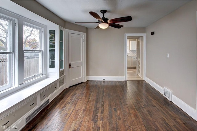 empty room featuring ceiling fan and dark hardwood / wood-style flooring