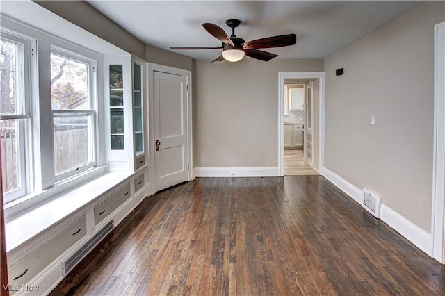 spare room featuring dark wood-type flooring and ceiling fan