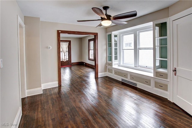 spare room with ceiling fan, plenty of natural light, and dark wood-type flooring