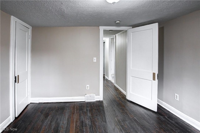 interior space with dark wood-type flooring and a textured ceiling