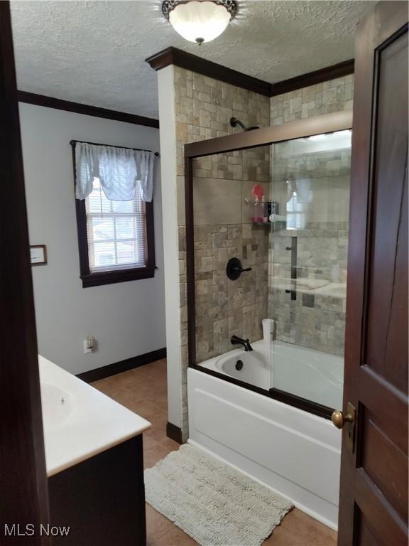 bathroom with ornamental molding, tile patterned flooring, a textured ceiling, and vanity