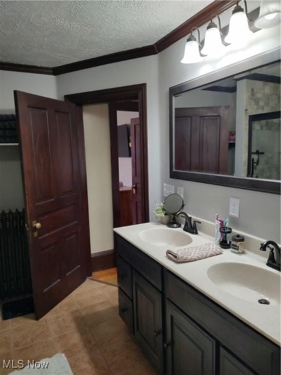 bathroom featuring vanity, ornamental molding, and a textured ceiling