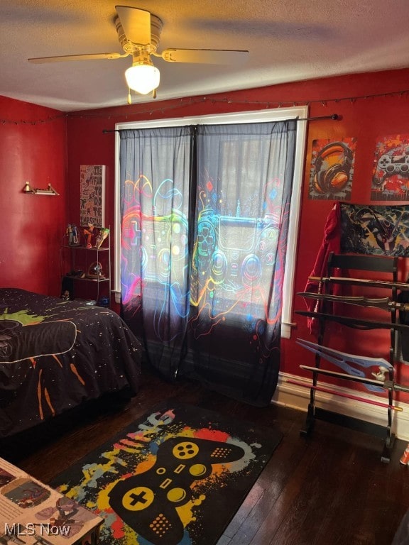 bedroom with ceiling fan, a textured ceiling, and hardwood / wood-style flooring