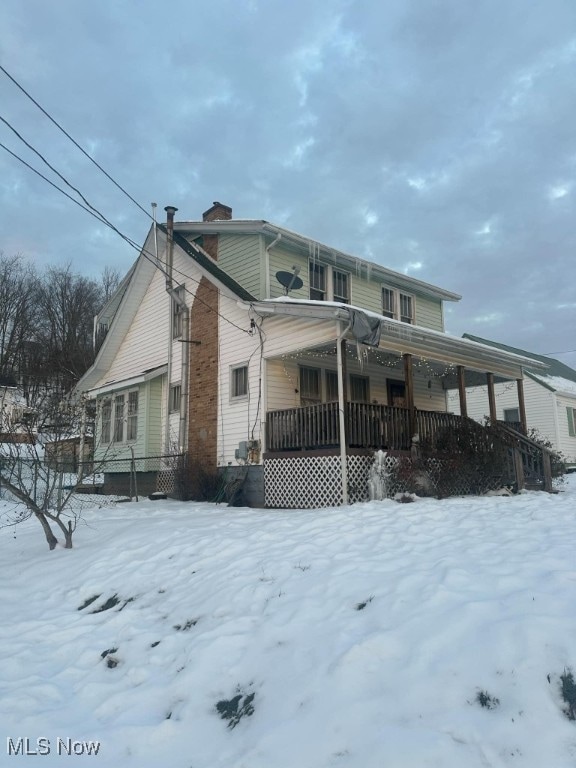 view of snow covered exterior featuring a porch