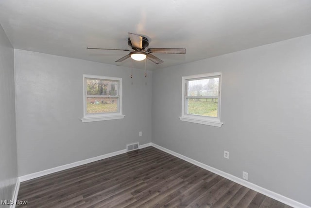 spare room featuring dark wood-type flooring and ceiling fan