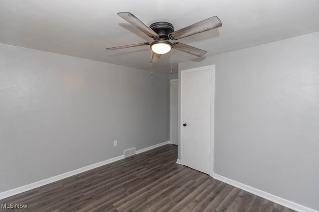 empty room featuring ceiling fan and dark hardwood / wood-style flooring