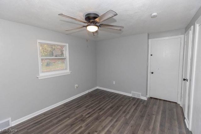 unfurnished room featuring dark wood-type flooring and ceiling fan