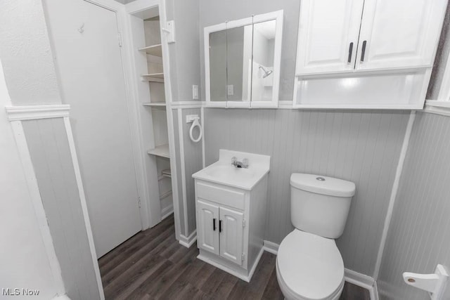 bathroom featuring wood-type flooring, toilet, and vanity