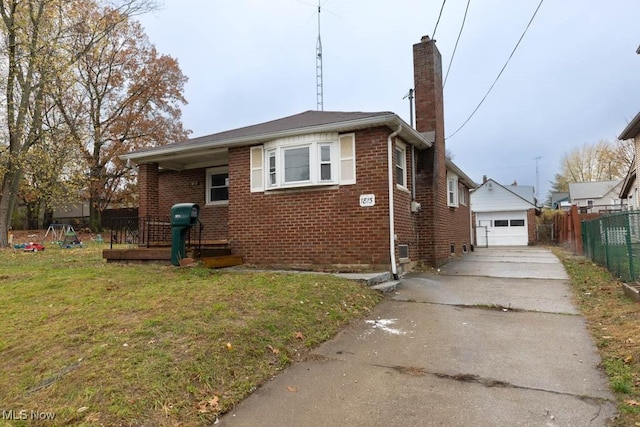 view of front of property with a front yard, a garage, and an outbuilding