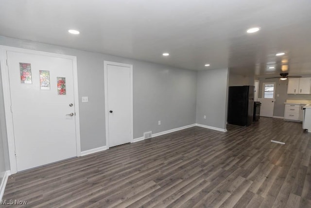 unfurnished living room with dark hardwood / wood-style floors and ceiling fan