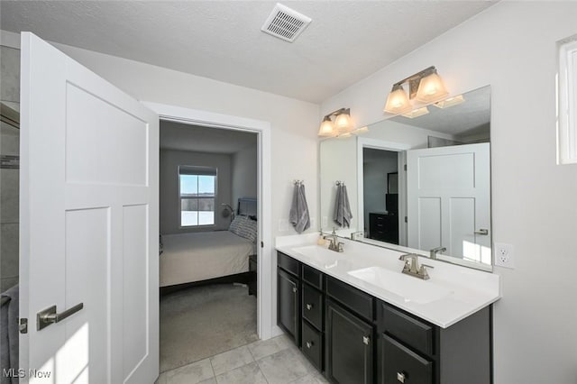 bathroom featuring a textured ceiling, vanity, and tile patterned flooring