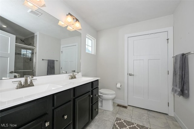 bathroom with walk in shower, vanity, tile patterned flooring, and toilet