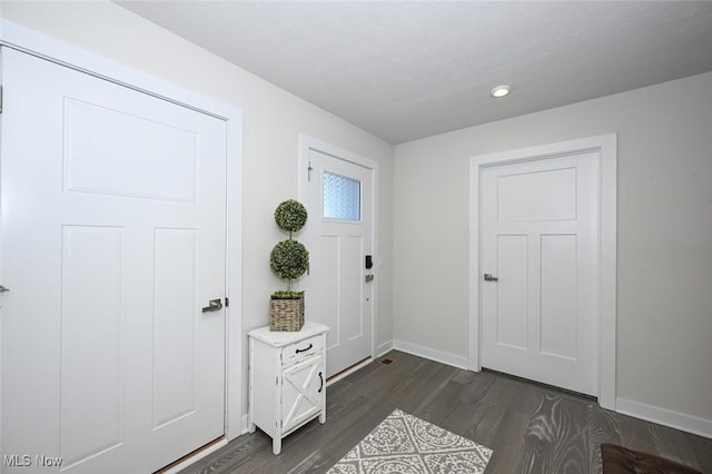 entryway with dark hardwood / wood-style flooring