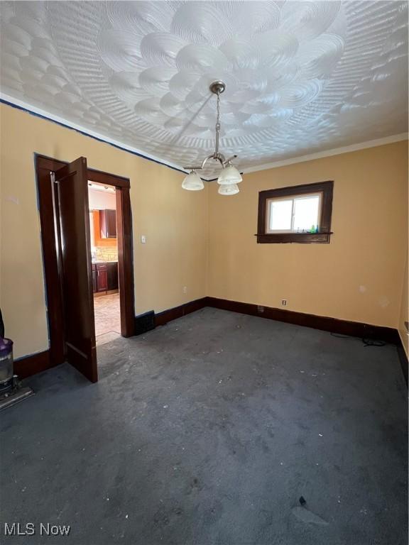 empty room featuring concrete floors and ornamental molding