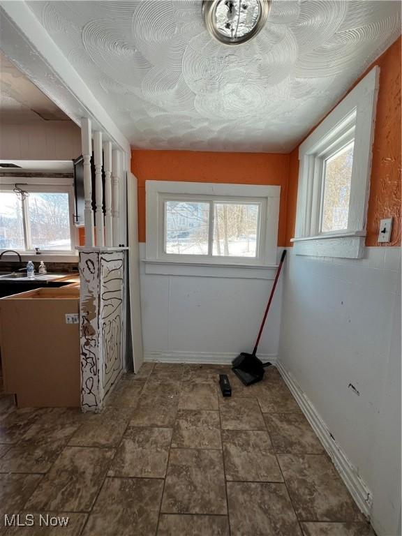 clothes washing area featuring a healthy amount of sunlight and sink