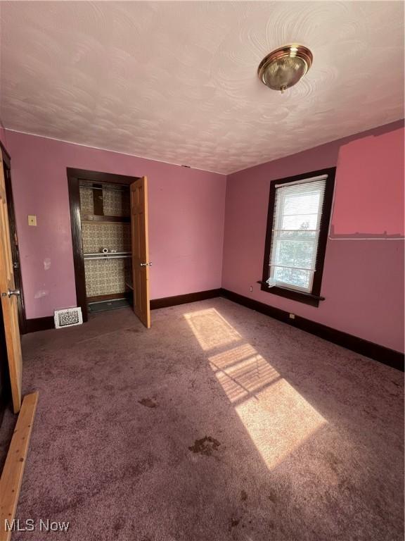 interior space featuring a textured ceiling and carpet