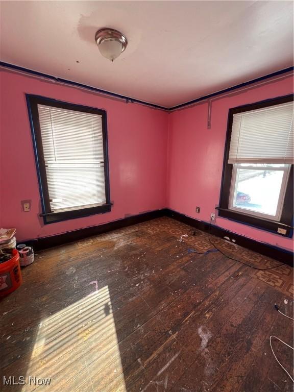 spare room featuring dark wood-type flooring and ornamental molding