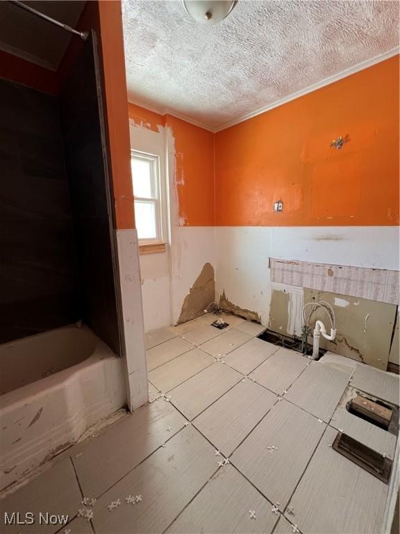 bathroom featuring a textured ceiling and a bath