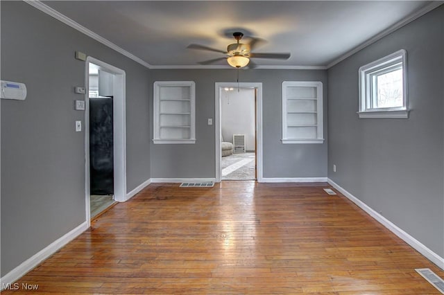 unfurnished room with built in shelves, ceiling fan, ornamental molding, and light hardwood / wood-style flooring