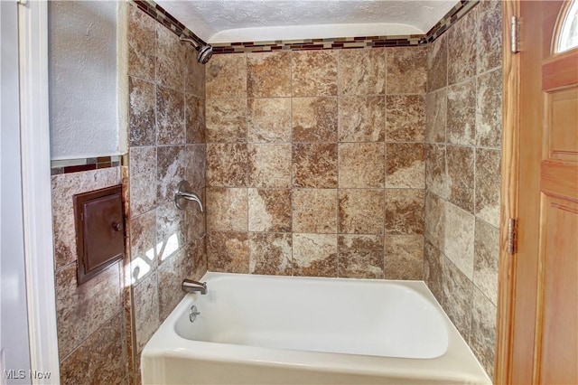 bathroom with shower / bath combination and a textured ceiling