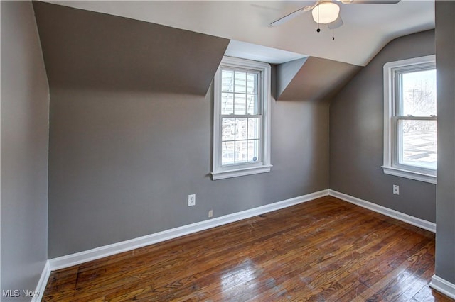 additional living space featuring ceiling fan, plenty of natural light, lofted ceiling, and dark hardwood / wood-style flooring