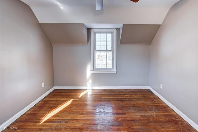 additional living space with dark hardwood / wood-style flooring, vaulted ceiling, and ceiling fan