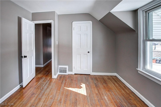 bonus room with vaulted ceiling and light wood-type flooring