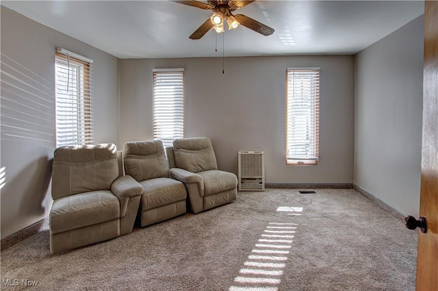 interior space with heating unit, a wealth of natural light, and ceiling fan