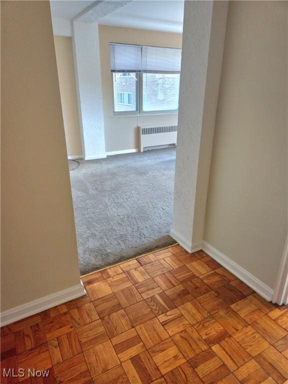 unfurnished room with light parquet floors and radiator