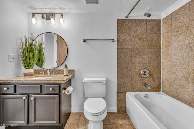 full bathroom featuring toilet, tiled shower / bath, vanity, and a textured ceiling