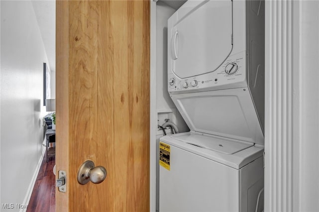 washroom with stacked washer / drying machine and hardwood / wood-style floors