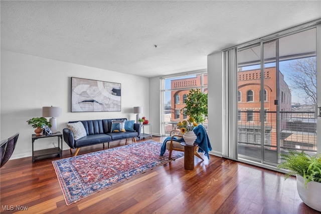 living room with a textured ceiling, dark hardwood / wood-style flooring, and floor to ceiling windows