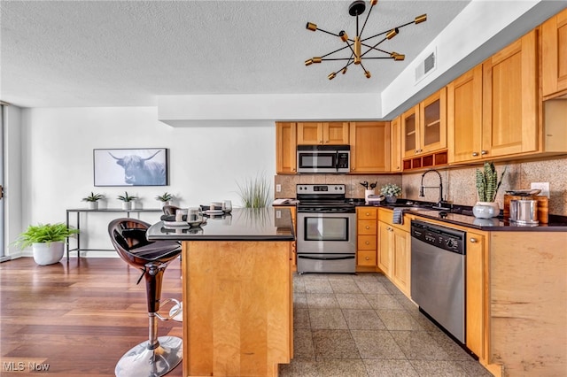 kitchen featuring a center island, sink, an inviting chandelier, a breakfast bar area, and stainless steel appliances