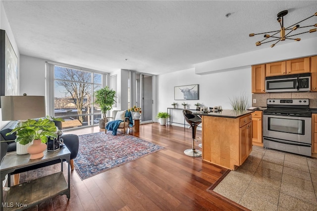 kitchen featuring a textured ceiling, a center island, stainless steel appliances, and a healthy amount of sunlight