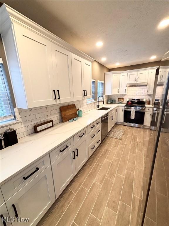 kitchen featuring appliances with stainless steel finishes, sink, and white cabinets