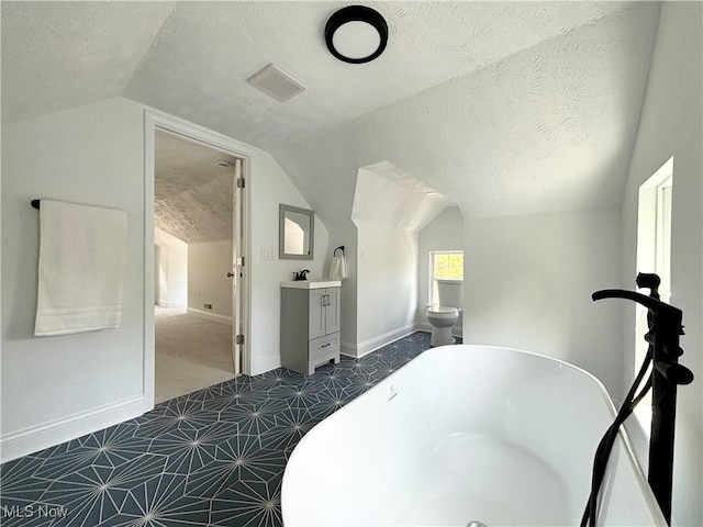 bathroom featuring lofted ceiling, toilet, a textured ceiling, and vanity