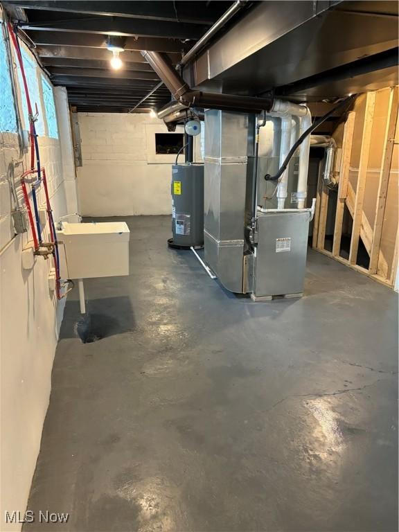 basement with heating unit, sink, and water heater