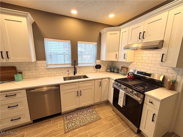 kitchen featuring tasteful backsplash, white cabinetry, appliances with stainless steel finishes, and sink