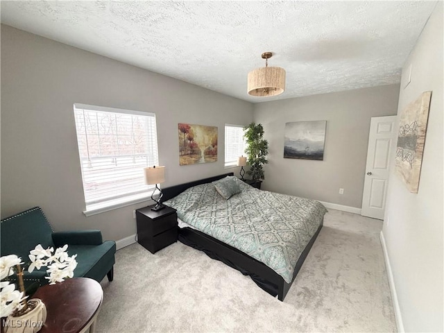 bedroom with light colored carpet and a textured ceiling