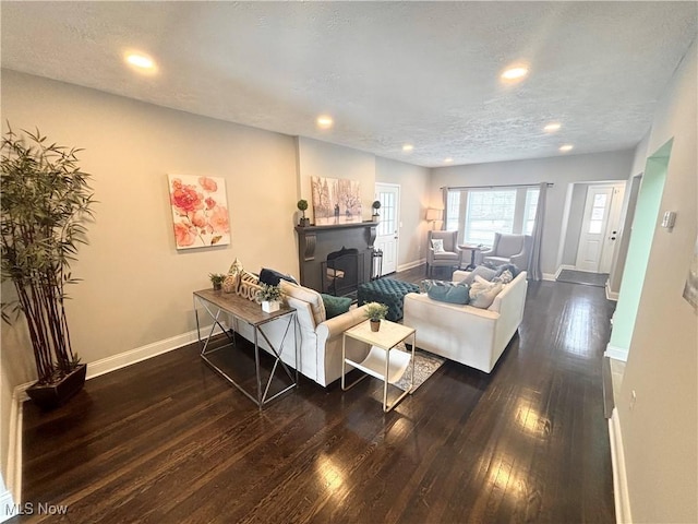 living room with dark hardwood / wood-style floors and a textured ceiling