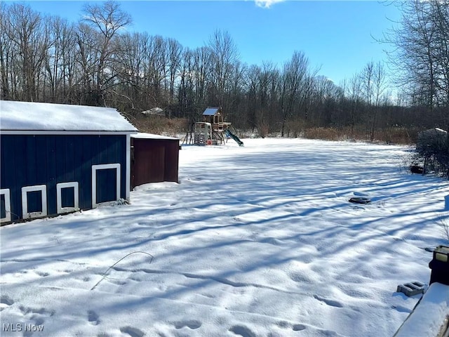 yard covered in snow with a playground