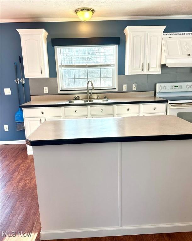 kitchen featuring wall chimney exhaust hood, white cabinetry, dark hardwood / wood-style flooring, white range with electric cooktop, and sink