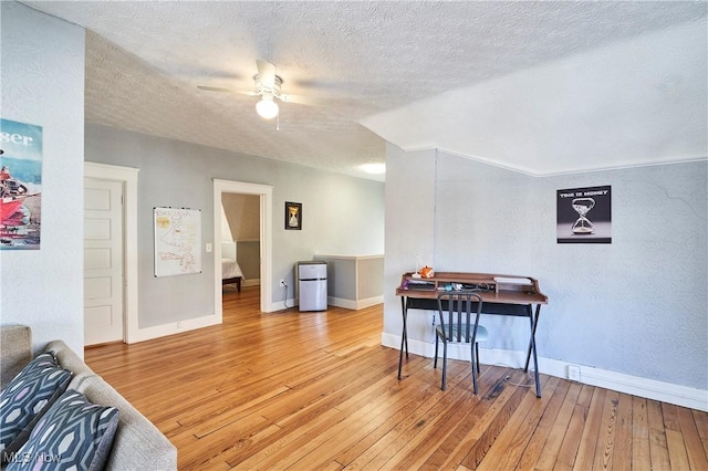 interior space with hardwood / wood-style flooring, a textured ceiling, ceiling fan, and vaulted ceiling